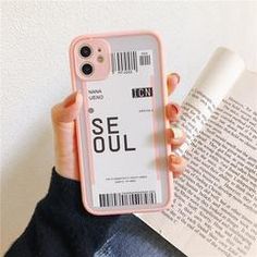 a person holding an iphone case with the name seul printed on it, in front of a book