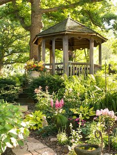 a gazebo surrounded by flowers and trees