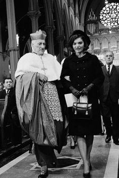 two people walking down the aisle of a church