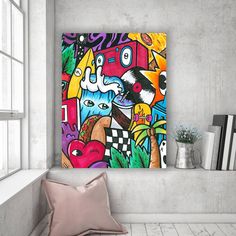 a colorful painting on the wall above a couch in a room with white walls and flooring