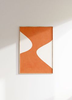 an orange and white painting hanging on the wall