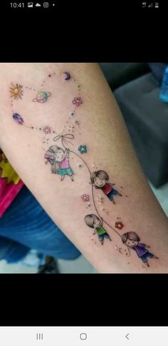 a person with a tattoo on their arm that has an image of two people flying in the sky