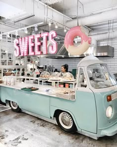 an ice cream truck parked in front of a doughnut shop with a donut sign above it