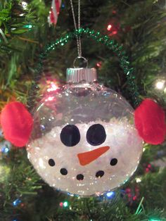 a snowman ornament hanging from a christmas tree