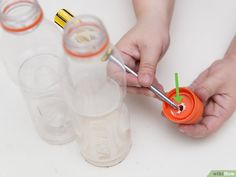 someone is holding an orange cup with two straws in it and some empty cups next to them