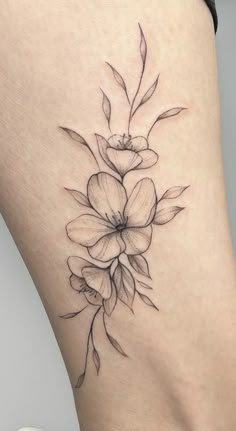 a black and white flower tattoo on the thigh