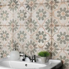 a white sink sitting under a bathroom mirror next to a wall mounted faucet