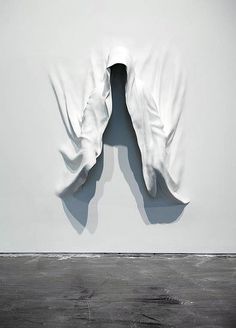 an abstract sculpture is shown in the middle of a room with white walls and black flooring