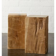 two wooden blocks sitting next to each other on top of a table in front of a white brick wall