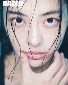 a close up of a person with wet hair on her face and hands in front of her face