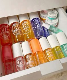 an open drawer filled with lots of different colored bottles