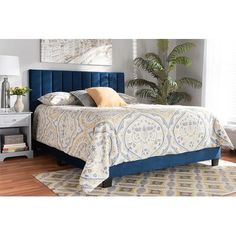 a bed with blue velvet headboard and foot board