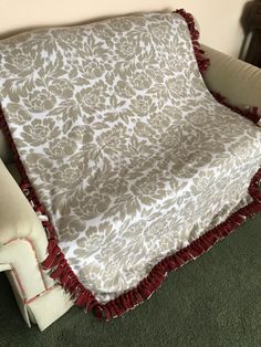 a white and red blanket sitting on top of a couch