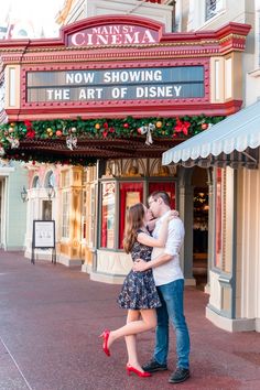 a man and woman kissing in front of a theater