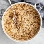 a bowl filled with oatmeal sitting on top of a table next to a spoon