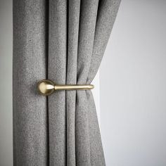 an open curtain with a gold handle on it