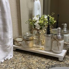 a bathroom counter with jars and soap dispensers