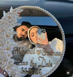 a man and woman taking a selfie in a car mirror with the reflection of their wedding day