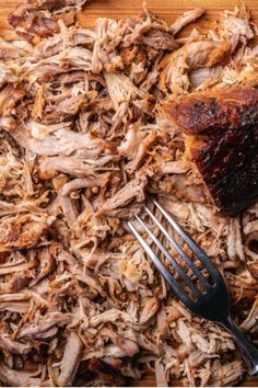 shredded meat on a cutting board with a fork