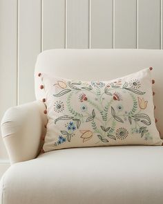 a white chair with a decorative pillow on it