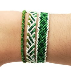 a person's arm with three bracelets on top of each other, one is green and the other is white