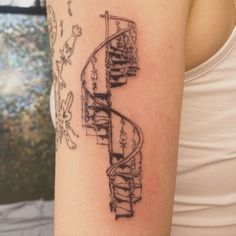 a woman's arm with a spiral staircase tattoo on it