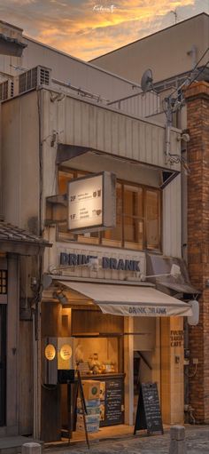 the outside of a building with an awning over it's entrance at sunset