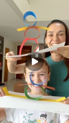 a woman and child holding up scissors in front of their faces with the same image on them