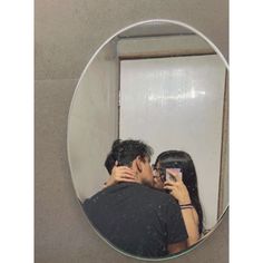 a man and woman taking a selfie in front of a mirror with their arms around each other