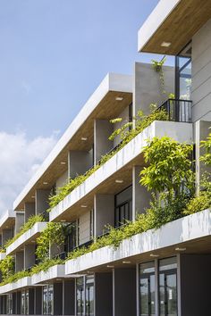 an apartment building with plants growing on the balconies