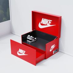 a pair of nike shoes are in a red shoe box with the logo on it