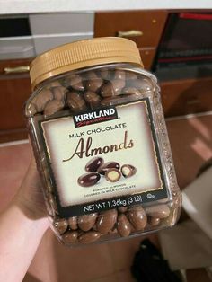 a jar filled with chocolate almonds sitting on top of a counter