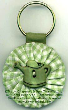 a keychain with a green teapot on it's side and a white background