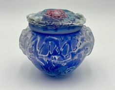 a blue glass vase with flowers on it