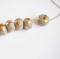 the necklace has five beads with gold foil on them