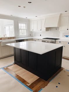 a kitchen with white cabinets and black island