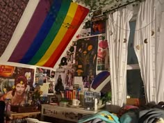 there is a rainbow flag hanging in the corner of this room with pictures on the wall