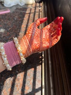 a woman's arm covered in henna and bracelets