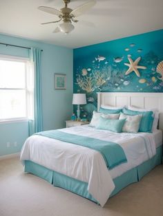 a bedroom decorated in blue and white with sea creatures on the wall above the bed