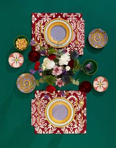 an overhead view of plates and flowers on a table