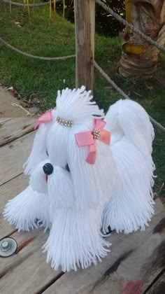 a white stuffed dog sitting on top of a wooden table