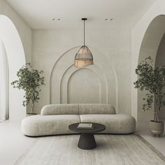 a living room with a couch, table and potted plants