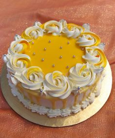 a yellow and white frosted cake sitting on top of a table