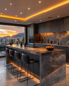 a kitchen with marble counter tops and bar stools next to an open floor plan