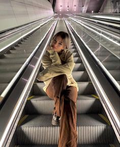 a woman sitting on top of an escalator