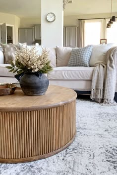 a living room filled with furniture and a large vase on top of a coffee table