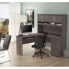 a desk with a computer on top of it in front of a chair and window