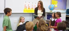 a woman standing in front of a group of children