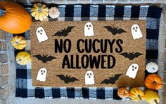 a door mat that says no cucuss allowed on it with pumpkins and gourds around it