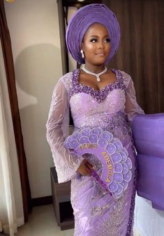 a woman in a purple dress holding a fan